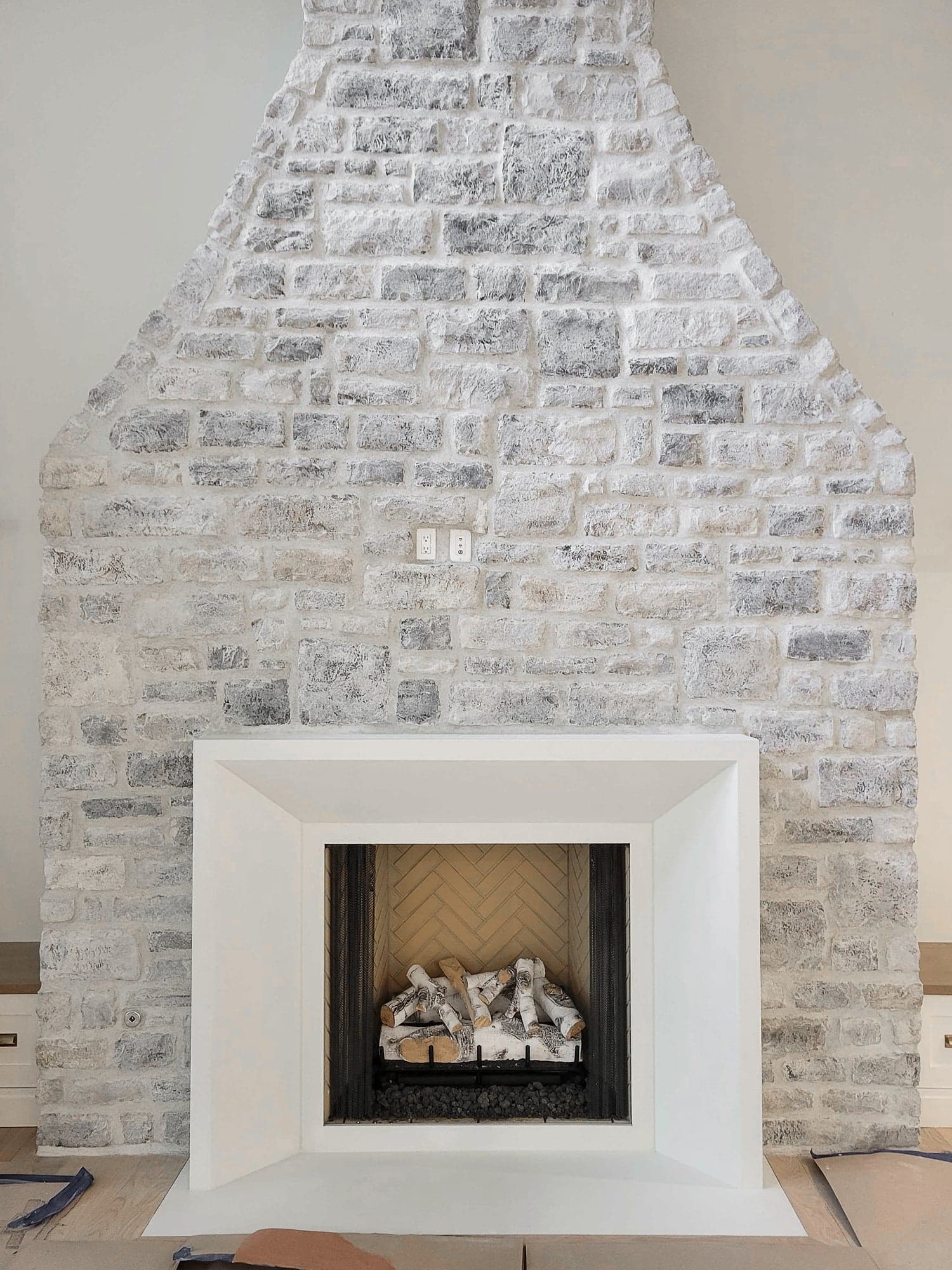 Cast stone fireplace surround on a limewashed stone chimney