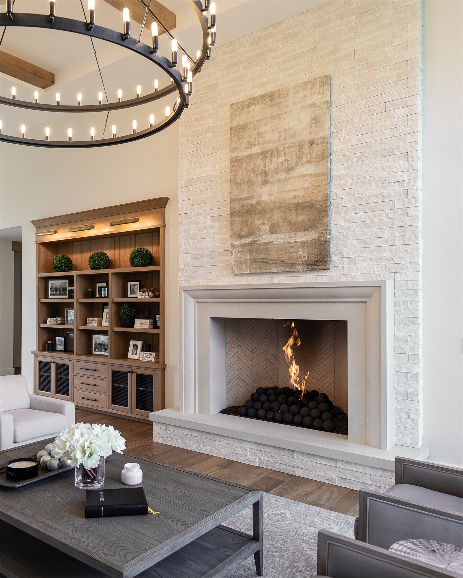 Custom cast stone fireplace with a live fire in a styled living room